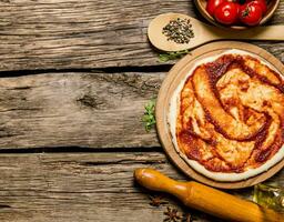 il lanciato su Pizza Impasto con pomodoro salsa, rotolamento perno e spezie. foto