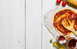 il lanciato su Pizza Impasto con pomodoro salsa e con un' rotolamento spillo. foto