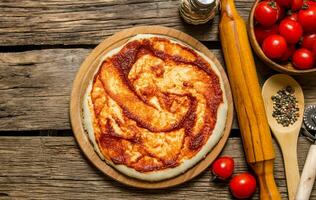 il lanciato su Pizza Impasto con pomodoro salsa, rotolamento perno e spezie. foto