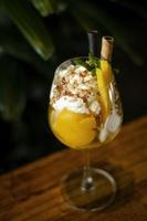 Coppa di gelato tropicale al mango biologico e frutto della passione nel bicchiere da vino