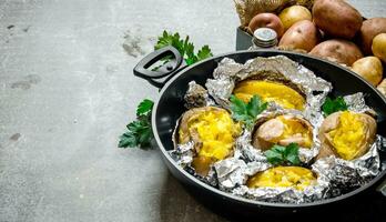 il concetto di al forno Patata nel Foglio su un vecchio rustico tavolo . gratuito spazio per testo. foto