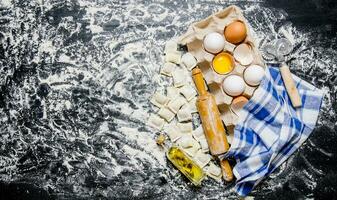 fresco ravioli con un' rotolamento spillo, uova e oliva olio. foto