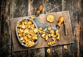 fresco funghi con un' coltello su un' taglio tavola. foto