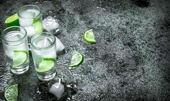 Vodka con pezzi di lime e ghiaccio cubi. foto