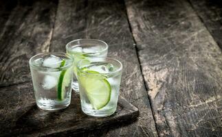 Vodka scatti con lime e ghiaccio su il tavola. foto