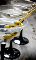 tre Martini con olive su un' nero tavolo. foto