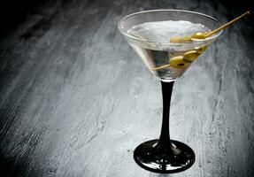 Martini con olive su un' nero tavolo. gratuito spazio per testo. foto