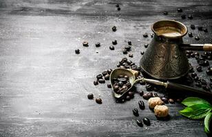 caffè pentola con caffè fagioli, canna zucchero e fresco le foglie. foto