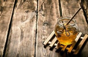 bicchiere vaso con naturale miele e un' cucchiaio. foto