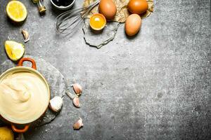 fresco Maionese con il ingredienti e frusta. foto