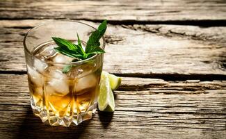 bicchiere di Rum con ghiaccio , lime e menta. foto