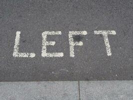 sinistra cartello dipinto su asfalto foto
