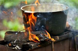 preparazione cibo su fuoco di bivacco foto