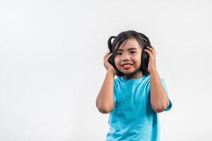 bambina che ascolta musica su cuffie wireless. foto