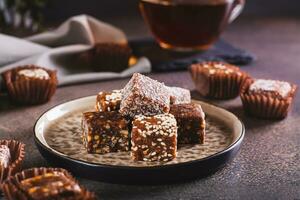 salutare caramelle fatto a partire dal fichi, date, noccioline, Noce di cocco e sesamo semi su un' piatto foto