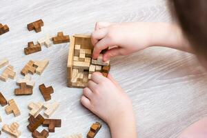 organizzazione e ordine. il bambino pieghe il di legno puzzle pezzi in un' pieghevole muffa. tempo libero per bambini foto