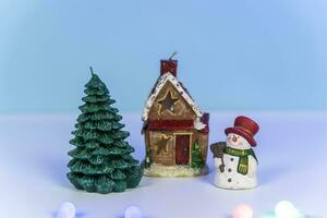 un' pupazzo di neve vicino un' favoloso inverno Casa e un' Natale albero foto