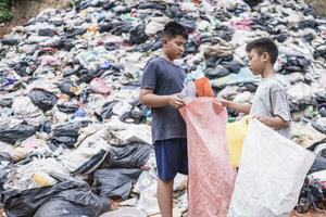 i bambini poveri raccolgono immondizia per la vendita a causa della povertà, il riciclaggio della spazzatura, il lavoro minorile, il concetto di povertà, la giornata mondiale dell'ambiente, foto