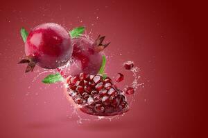 creativo disposizione fatto a partire dal fresco Melograno frutta e acqua spruzzi su rosso sfondo. foto