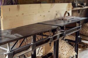 la lavorazione del legno macchina nel il carpenteria laboratorio nel avvicinamento. rustico officina. foto