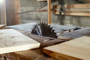 circolare macchina con molti diverso di legno spazi vuoti e tavole. vecchio rustico del falegname officina. circolare ruota avvicinamento, nel luce del sole. foto