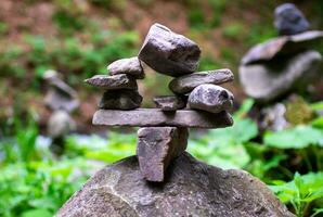 morbido messa a fuoco, avvicinamento di un' pila di pietre nel Perfetto equilibrio nel un' montagna foresta. roccia piramide, roccia equilibratura arte. meditazione, equilibrio, pace. passatempo. foto