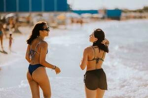 Due bella giovane donna avendo divertimento su il mare foto