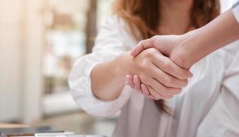 primo piano di uomini d'affari che si stringono la mano, finendo la riunione foto