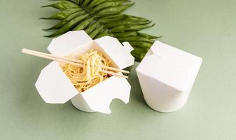 scatola di carta per wok aperta con noodles e bacchette