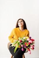 bella giovane donna bruna con bouquet di tulipani rosa freschi foto