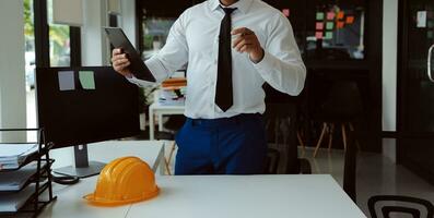 costruzione e struttura concetto di ingegnere o architetto incontro per progetto Lavorando con compagno e ingegneria utensili su modello edificio e planimetria nel Lavorando luogo, contrarre per tutti e due aziende. foto