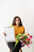 donna con bouquet di tulipani freschi e appunti in bianco per mock up foto