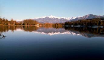 sereno bellezza blu lago nel Savoie con neve capped montagne foto