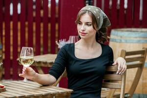 bellissimo giovane donna potabile bianca vino su il terrazza di un' ristorante. foto