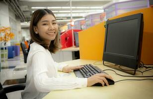 bellissimo asiatico ufficio donna contento e sorridente nel aziendale ufficio. foto