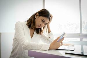 bellissimo asiatico attività commerciale donna o Lavorando ragazza nel vicino su tiro è stressato su di sua opera Questo mese su il scrivania nel sua ufficio. foto