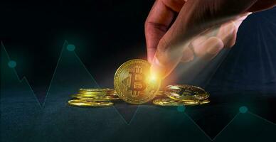 mano Tenere bitcoin a partire dal pila, d'oro bitcoin su nero sfondo con grafico grafico di azione mercato investimento commercio, crypto moneta concetto. foto