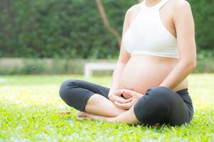 incinta asiatica giovane donna rilassarsi nel parco.