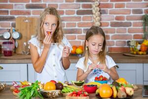 Due poco ragazze nel il cucina con fresco verdure. salutare cibo concetto. contento sorelle. foto