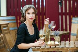 bellissimo giovane donna potabile bianca vino su il terrazza di un' ristorante. rilassante dopo opera con un' bicchiere di vino. singolo donna avendo divertimento. foto