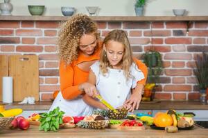 contento madre e figlia siamo avendo divertimento nel il cucina. salutare cibo concetto. foto