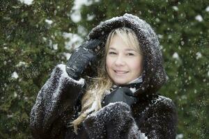 donna nel un' pelliccia cappuccio coperto con neve foto