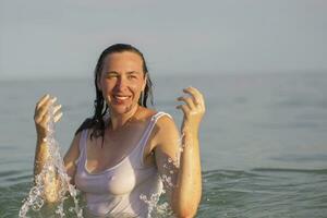 anziano donna nel mare acqua. di mezza età donna bagnarsi nel il oceano. foto