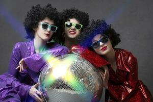 musica o danza gruppo di ragazze nel discoteca stile in posa su un' grigio sfondo con un' discoteca sfera. il danza era di il anni ottanta e in ritardo anni settanta. foto