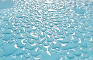 goccioline d'acqua astratte scintillanti su sfondo azzurro foto