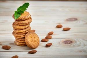 Biscotti al forno ripieni di crema di latte e mandorle su tavola di legno foto