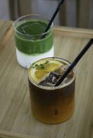ghiacciato matcha tè verde e ghiacciato nero arancia caffè su di legno tavolo foto