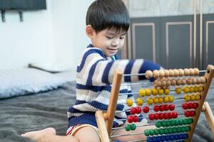 asiatico ragazzo giocando con giocattoli su il letto foto