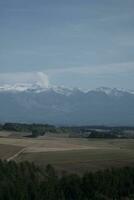 nuvole al di sopra di il montagne e aziende agricole foto