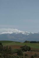 nuvole al di sopra di il montagne e aziende agricole foto